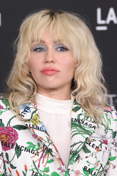 Miley Cyrus wearing a mediumlength blonde wolf cut and a floral Balenciaga jacket