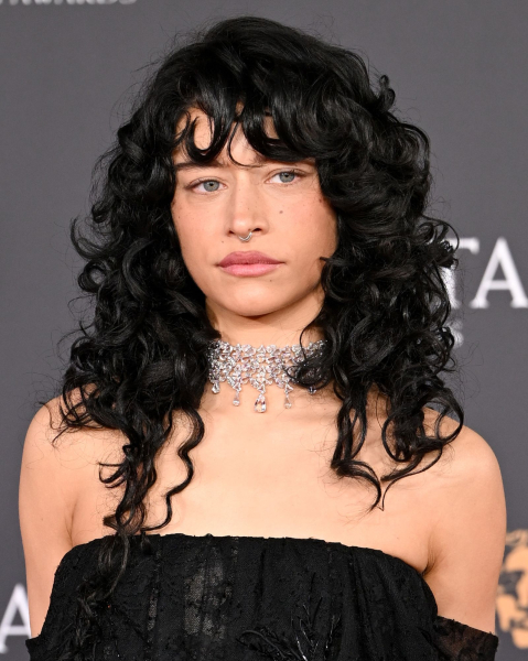 Odessa A'zion wearing a curly wolf cut diamond choker and black off the shoulder dress